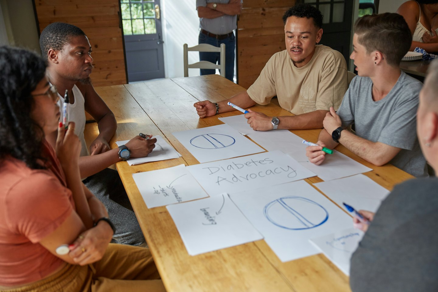 Team brainstorming ideas around a rustic wooden table.
